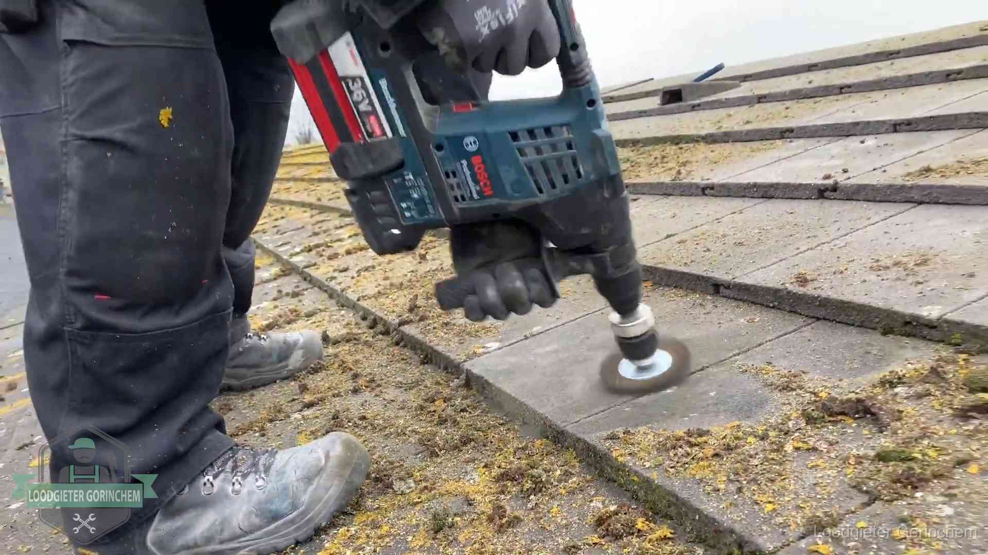 Betonnen dakpannen worden machinaal gereinigd tijdens dakonderhoud in Gorinchem