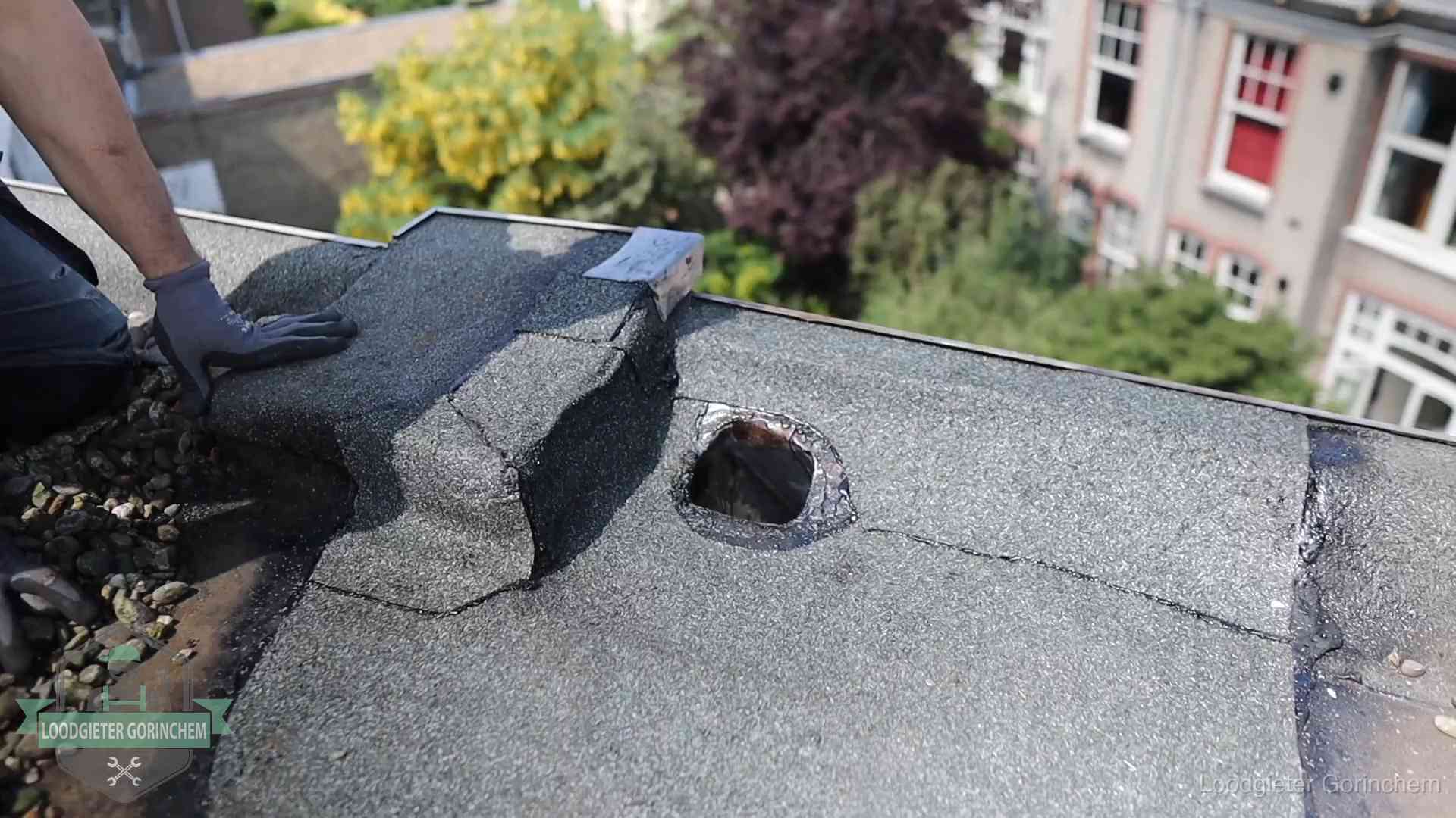 Loodgieter inspecteert een beschadigd bitumen plat dak tijdens een daklekkage-inspectie in Gorinchem
