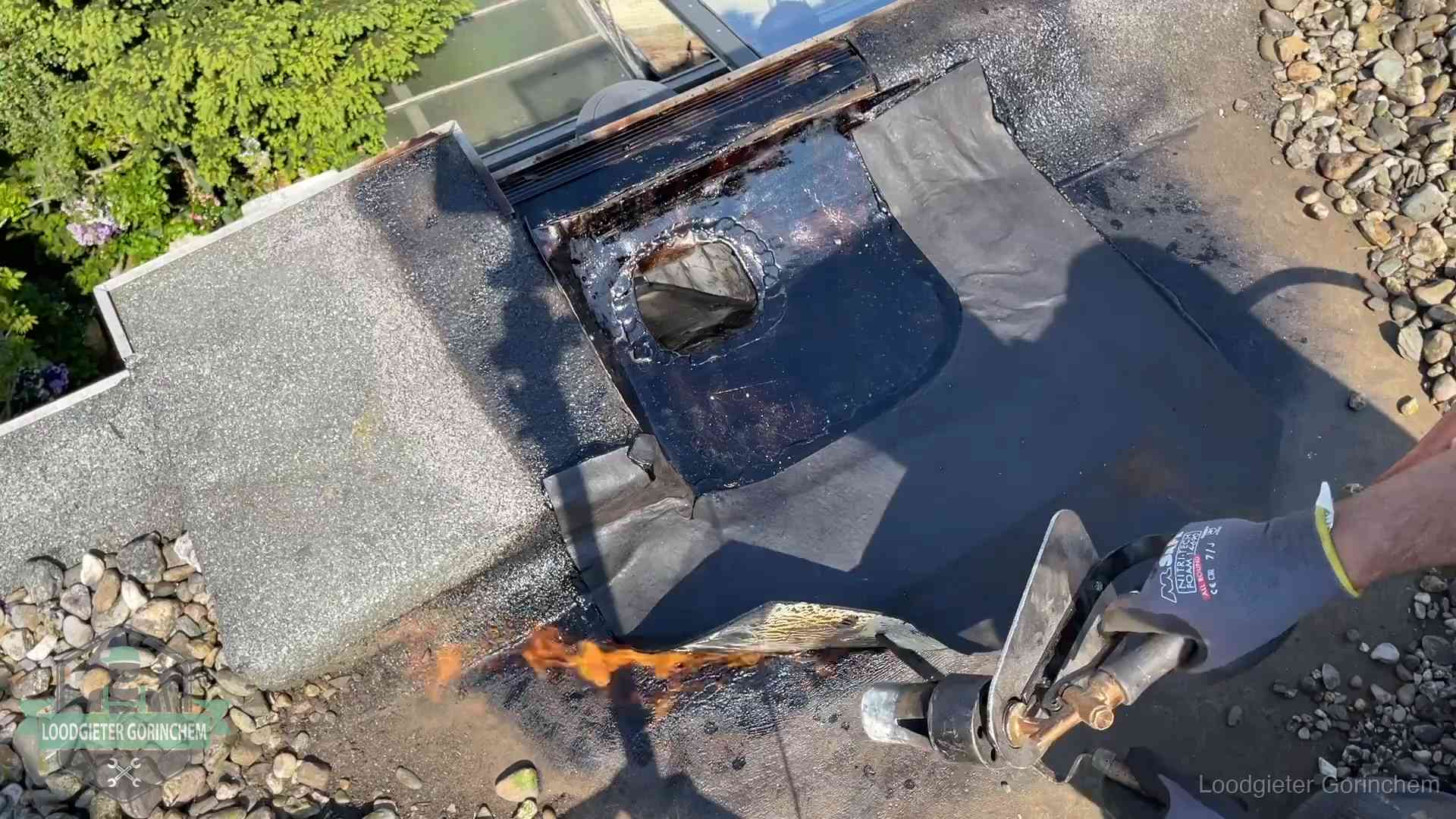 Dakdekker brandt bitumen rond een doorvoer tijdens een daklekkage-reparatie in Gorinchem
