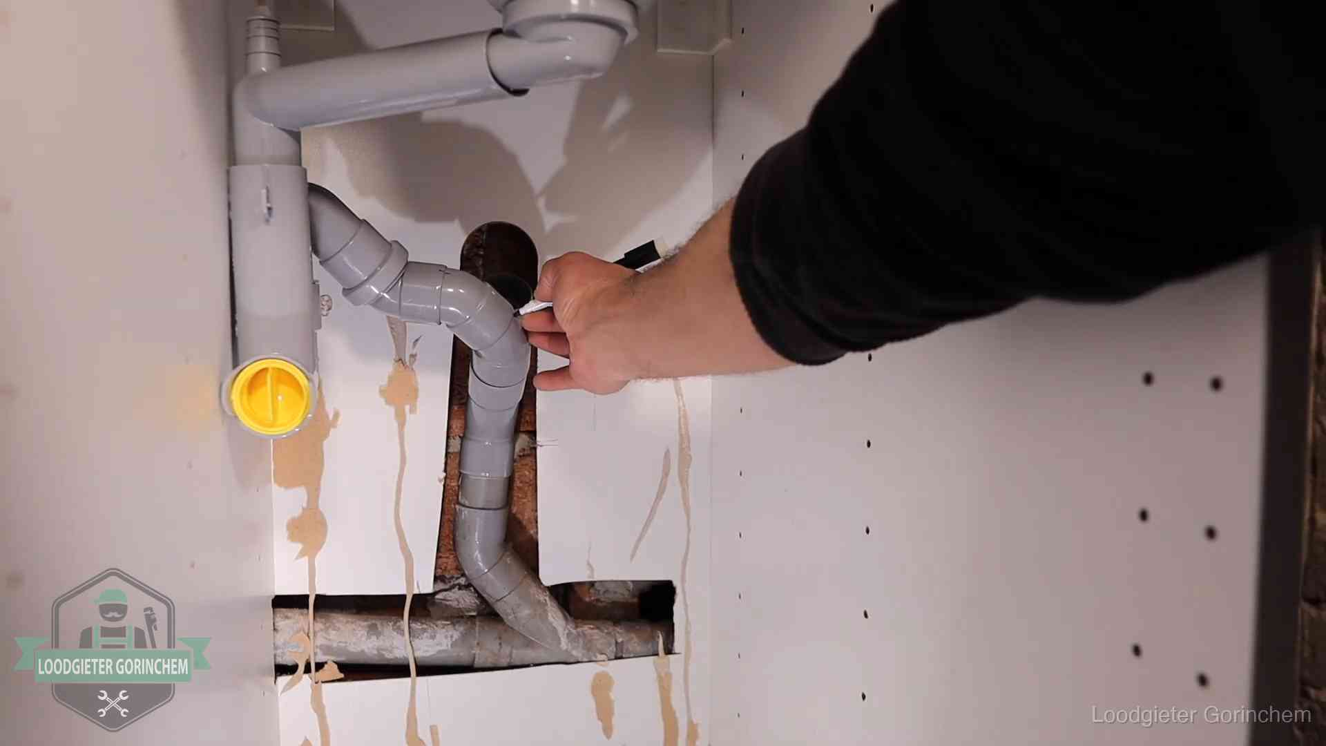 Loodgieter markeert een pvc-afvoerbuis onder een gootsteen in Gorinchem