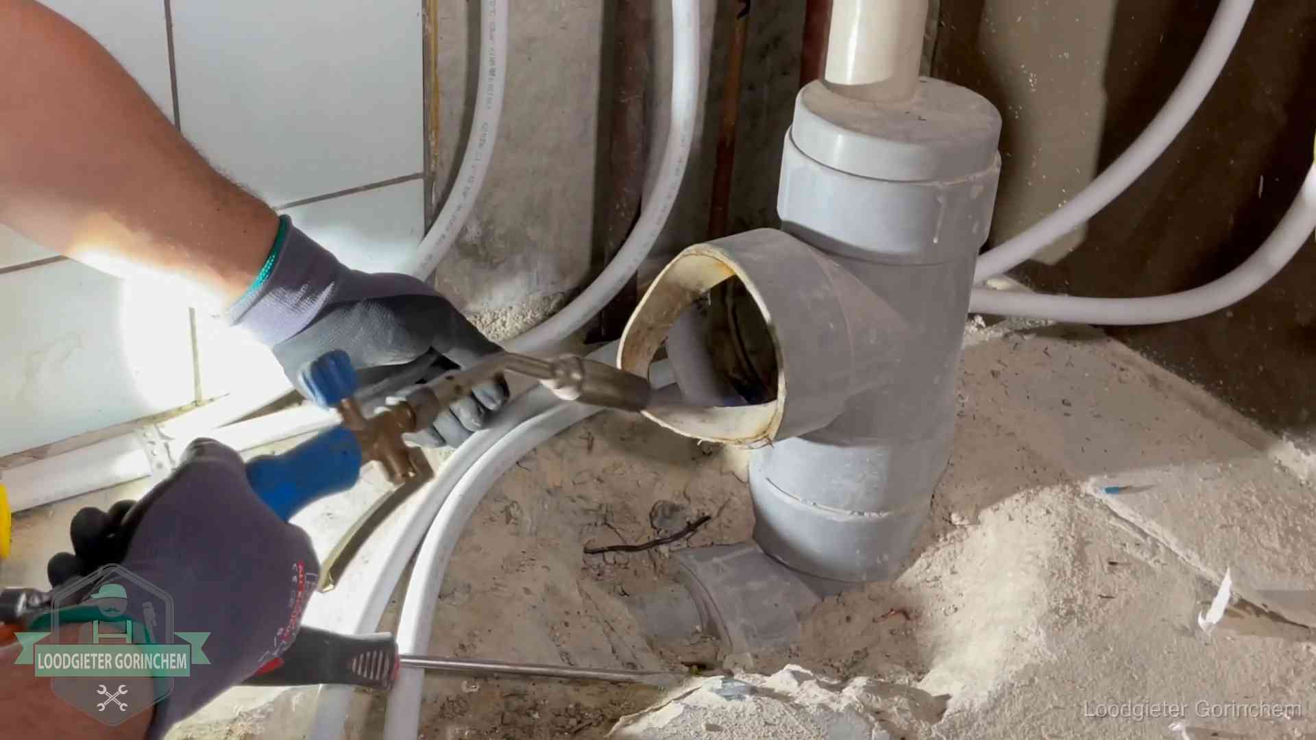 Loodgieter werkt met brander en messing kraanwerk aan leidingen in Gorinchem