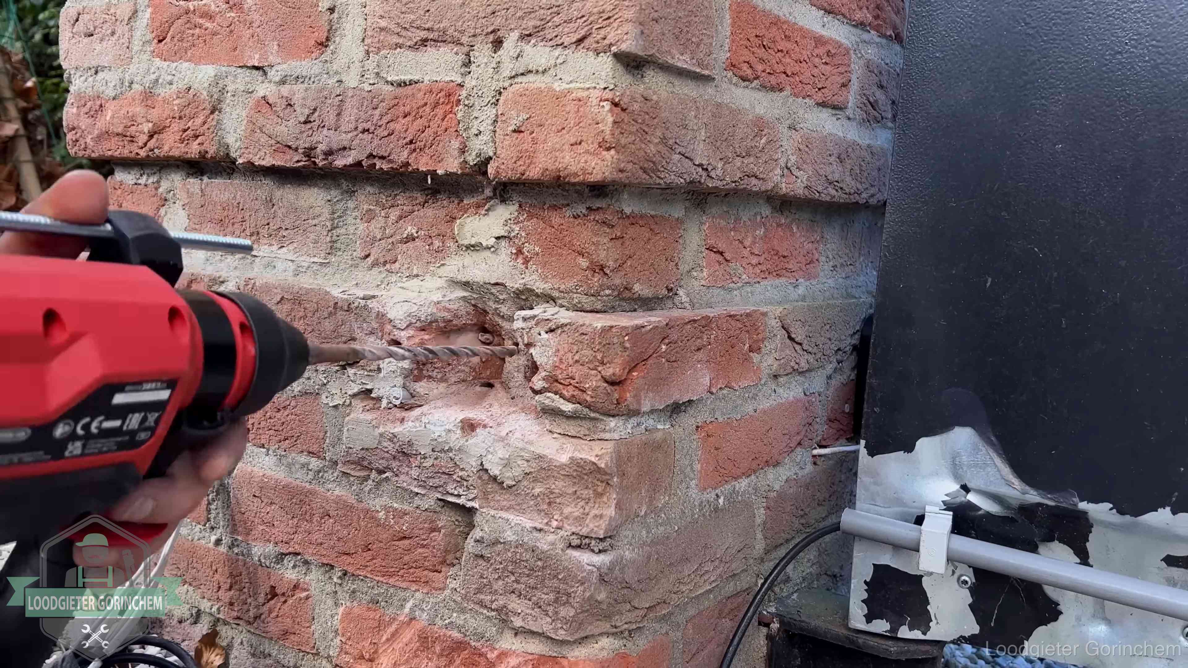 Vakman boort in de buitenmuur van een woning in de regio Gorinchem