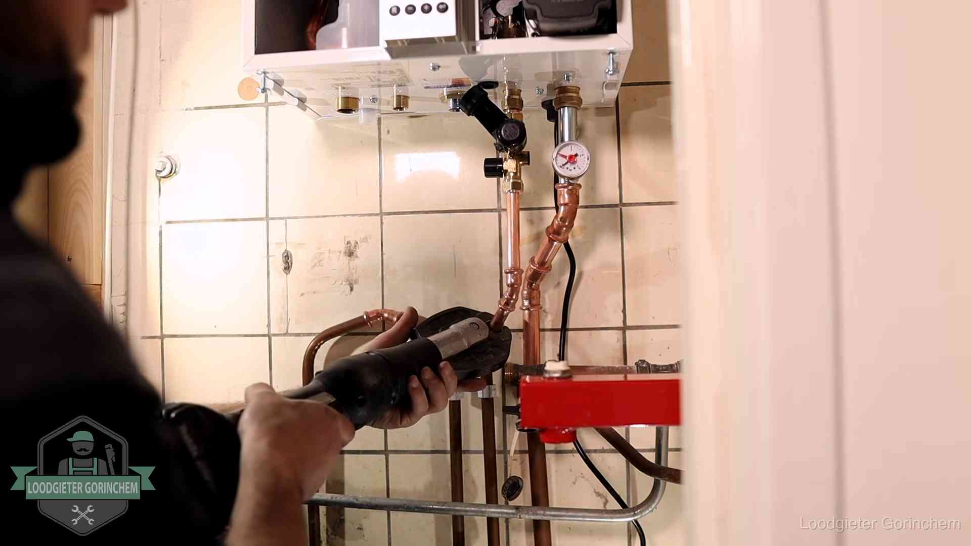 Cv-ketel onderhoud in Gorinchem Monteur werkt aan de leidingen onder een cv-ketel in Gorinchem