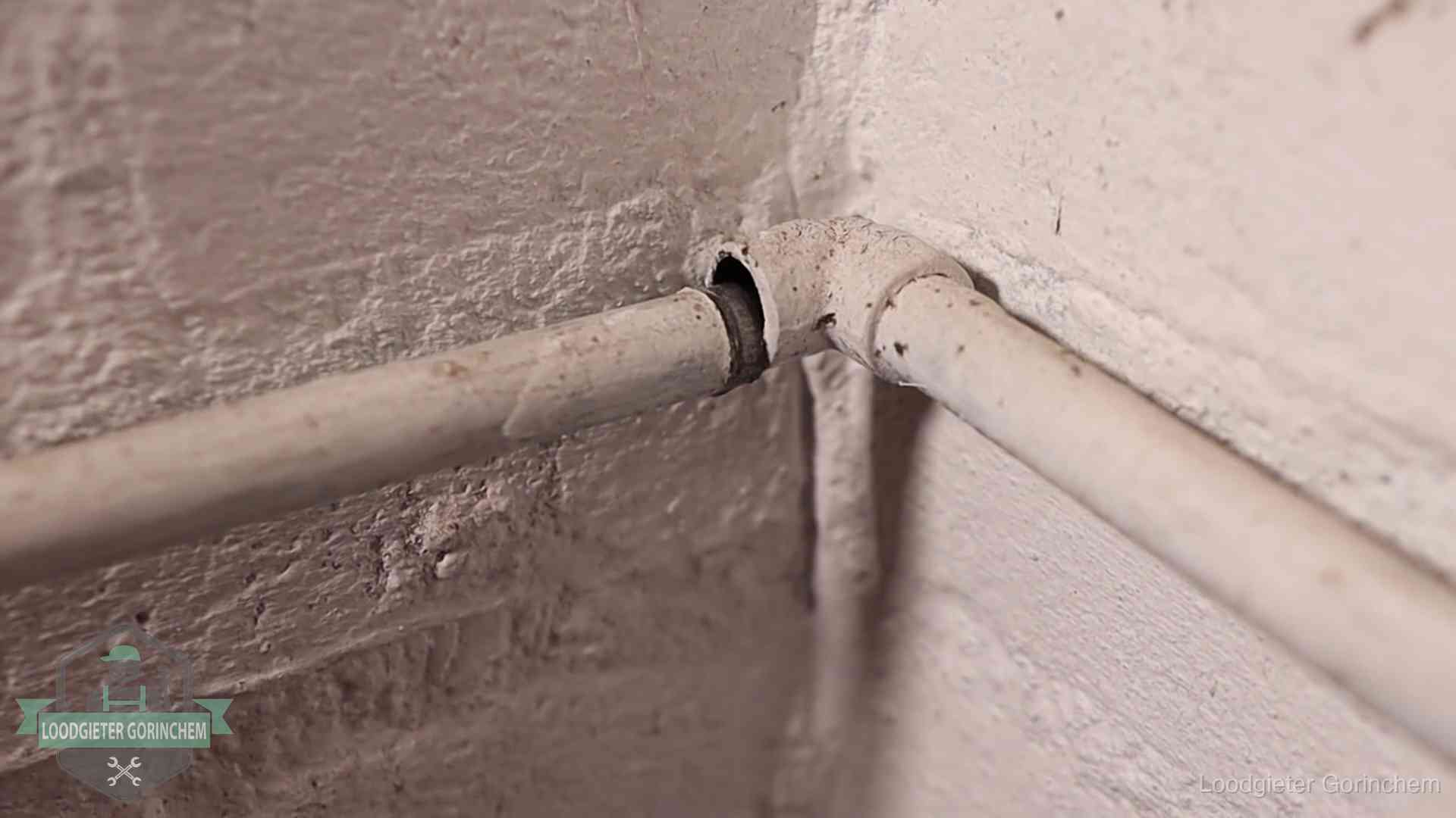 Oude geverfde waterleiding met een losliggende fitting in een woning in Gorinchem