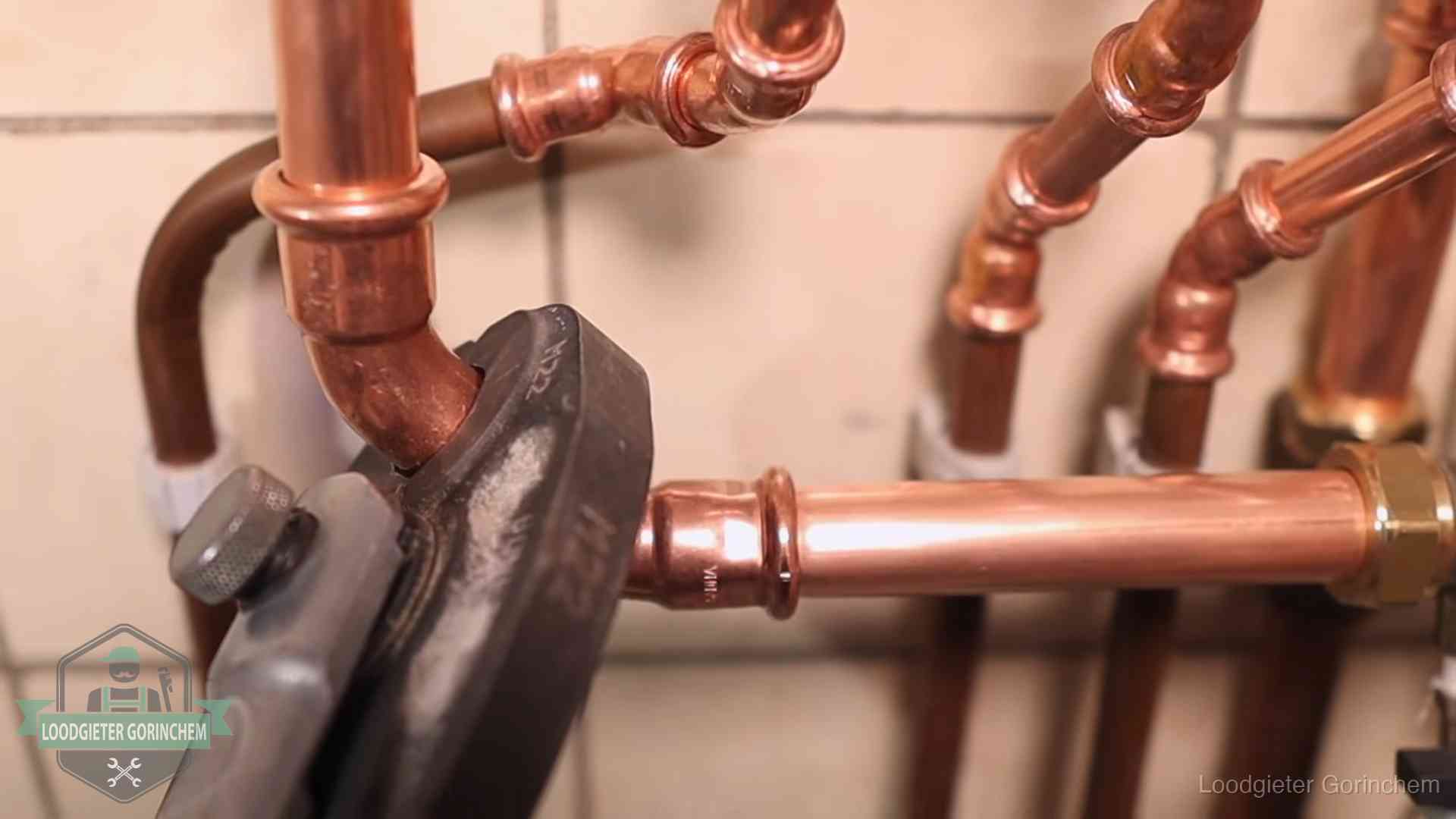 Persmachine perst een koperen fitting op nieuw leidingwerk in Gorinchem