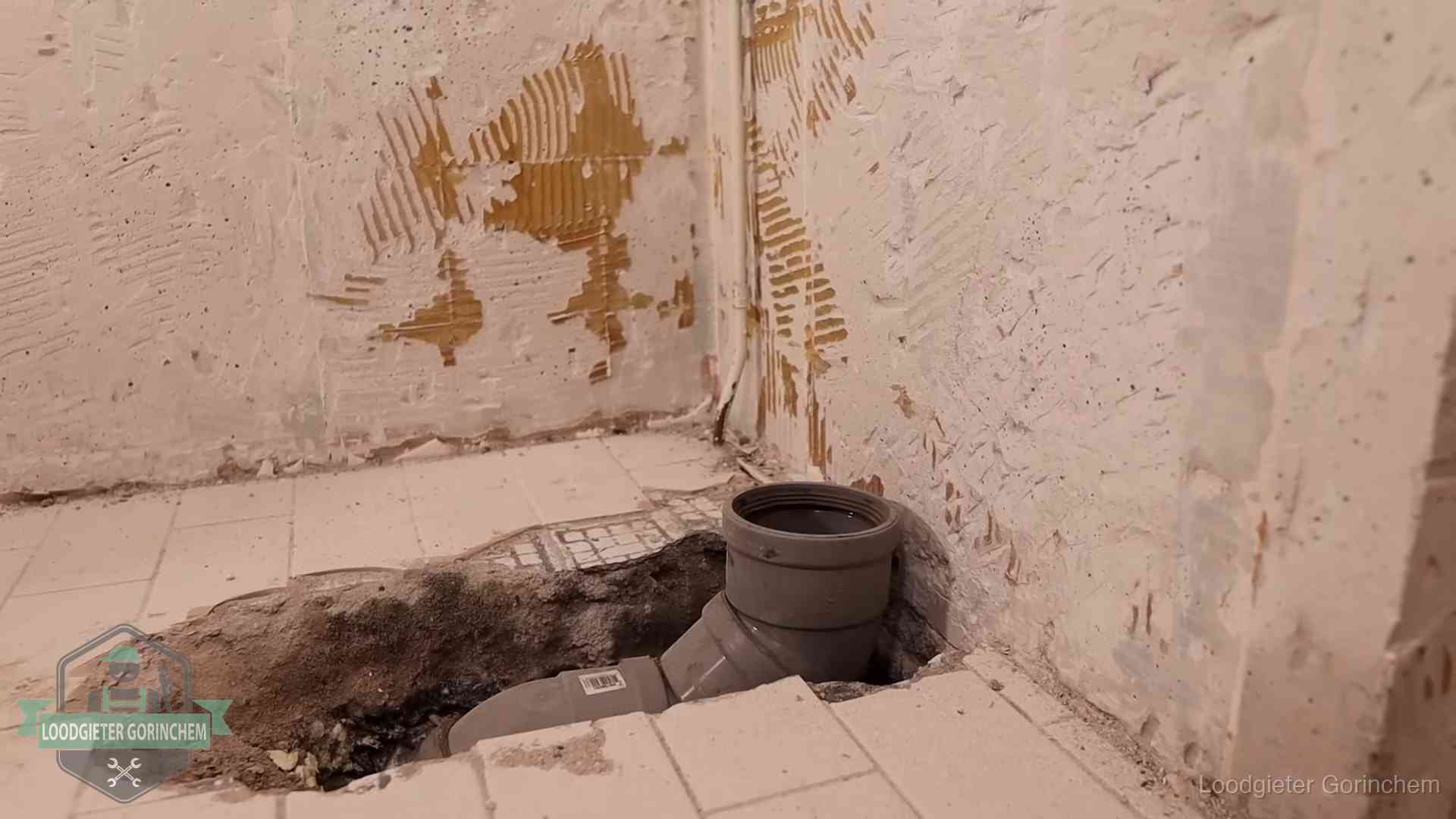 Verzakt riool herstellen in Gorinchem Opengebroken vloer met een nieuwe pvc-rioolbocht in een gegraven sleuf in Gorinchem