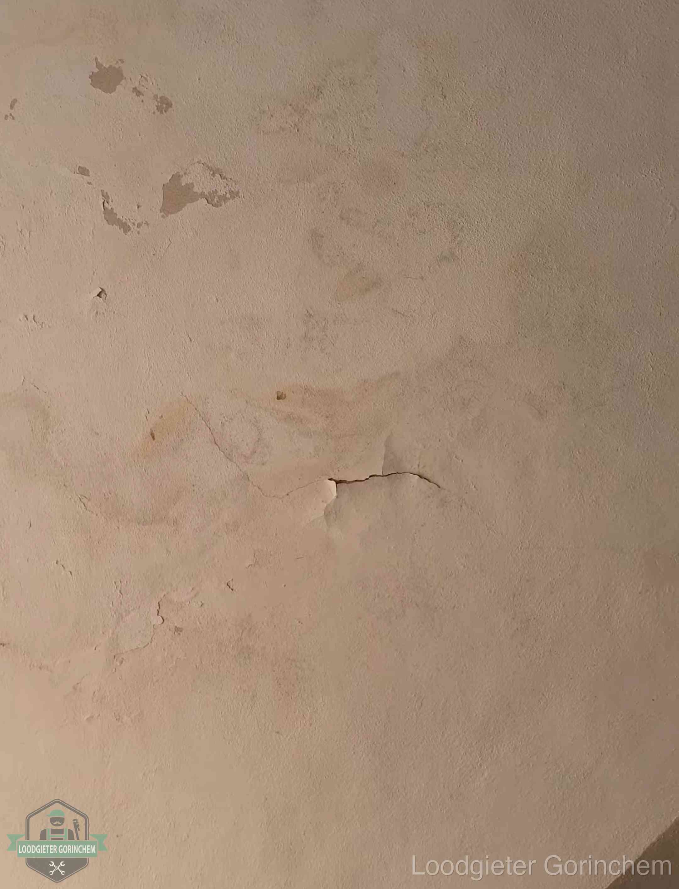 Vochtkringen en afbladderende verf op een plafond in Gorinchem, schade voor het meetrapport en de verzekering